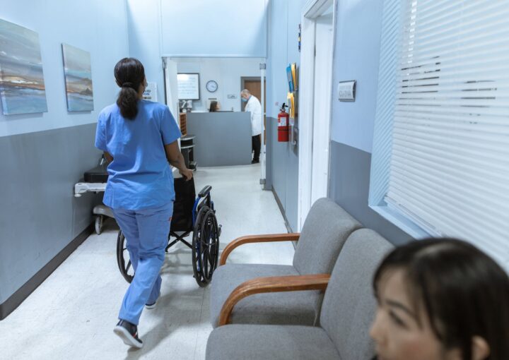 Krankenschwester schiebt einen Rollstuhl auf dem Flur des Krankenhauses